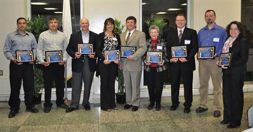Hall of Achievement winners pose in a group with their plaques
